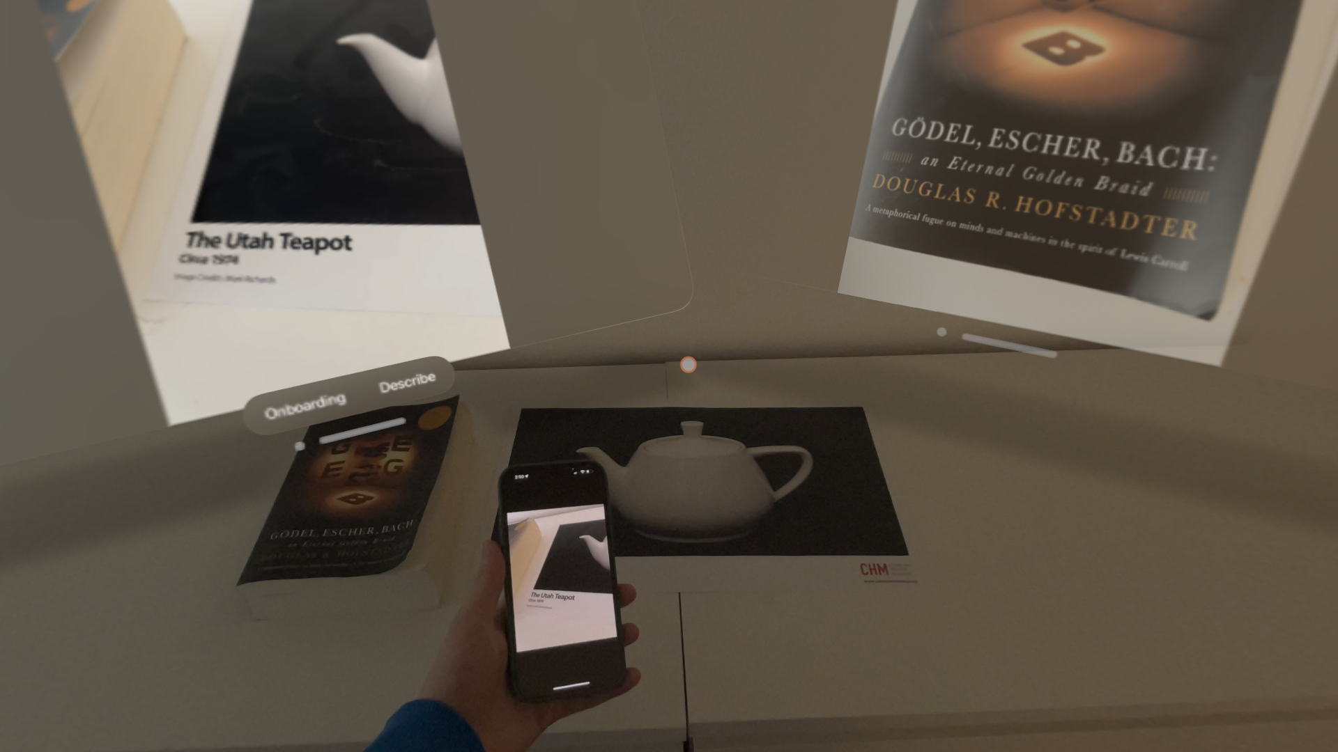 Spatial Continuity on Vision Pro showing a live iPhone camera view and an enlarged image of a book cover.